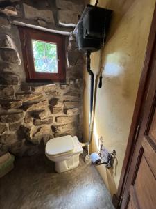 马德普拉塔阿雷胡耶山林小屋的石质浴室设有卫生间和窗户。