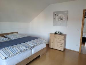 基尔夏姆Rudis Ferienwohnung的一间卧室配有一张床和一个木制梳妆台
