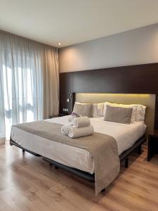 格拉纳达Hotel Tent Granada的一间卧室配有一张大床和毛巾