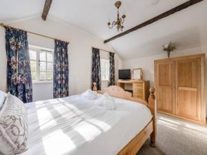 什鲁斯伯里Pass the Keys Shrewsbury Grade 2 Listed Black White Cottage的一间卧室配有一张带蓝色窗帘的大床