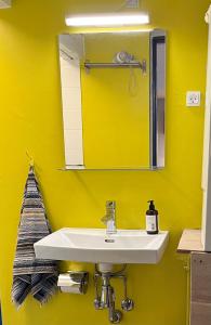 MillingeMillinge Gamle Skole的黄色的浴室设有水槽和镜子