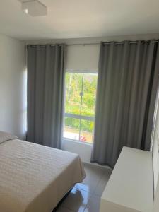 特里温福Condomínio Villa Verde Triunfo的一间卧室设有一张床和一个窗口