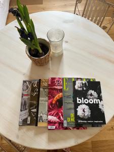 博洛尼亚Bloom as you are的一张带书和植物的白色桌子