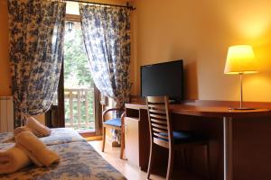 埃斯波特索拉特酒店的一间卧室配有书桌、一张床和一台电视。