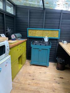 维德尼斯Boho Glamping的厨房配有蓝色炉灶和黄色橱柜