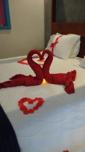 卡皮托利乌Pousada Vila do Lago的两只红色蛇在床上形成心