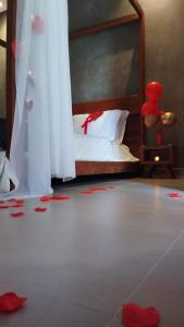 卡皮托利乌Pousada Vila do Lago的卧室配有一张红色花瓣床,位于地板上