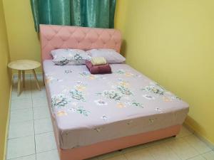 汝来Damai Eco Homestay Nilai Negeri Sembilan的一张带粉红色床头板和枕头的小床