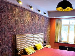 里加Dzelzavas Residence的一间卧室配有紫色墙壁、一张床和黄色枕头