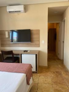 阿奎拉兹Pousada Tropical Ilhas的配有一张床和一台平面电视的酒店客房