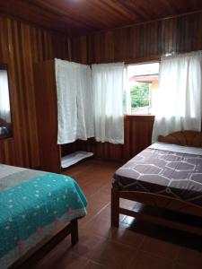 马尔多纳多港DouchkaHouse的一间卧室配有床和白色窗帘的窗户