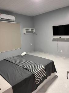 博阿维斯塔Confortável APTO em Boa Vista.的客房设有一张床和一台平面电视。