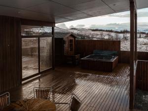 弗吕济Golden Circle Villa - Hot Tub & Sauna的甲板上设有热水浴缸和桌椅