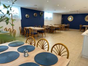 EdelényDanelis Hotel的一间带桌椅和蓝色墙壁的餐厅