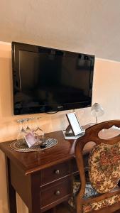Ponte San NicoloLa busa camere e trattoria的一张木桌,墙上挂着大电视