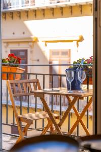 巴勒莫Natoli Apartments的阳台上的木桌和两杯酒杯