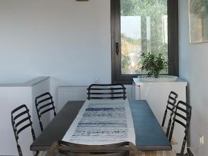 KamáriaLIOFYTO - Stylish villa with views to Foinikounda bay的一间带桌椅和窗户的用餐室