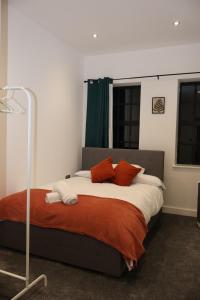 伯明翰Modern home in Birmingham的一间卧室配有带橙色和白色枕头的床