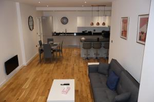 伯明翰Modern home in Birmingham的客厅以及带沙发和桌子的厨房。