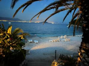 斯拉汀Hotel Marco Polo的海滩上设有躺椅,大海上设有沙滩