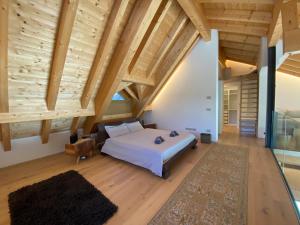 坎波罗索因瓦尔坎纳尔Luxury Chalet in the Tarvisio mountains的一间卧室设有一张大床和木制天花板。