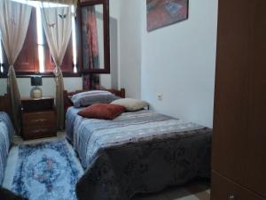 帕拉代西翁老屋酒店的一间卧室设有两张床和窗户。