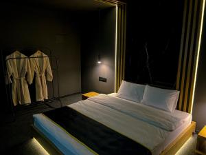 阿拉木图Atlas Hotel的一间带床铺的卧室,位于带衣架的房间内