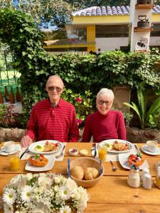 ChecaHosteria Casa Silva的年纪较大的男人和女人坐在餐桌旁吃着食物