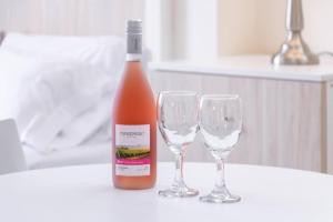 利马Residencial Suiza的桌子上放有一瓶葡萄酒和两杯酒