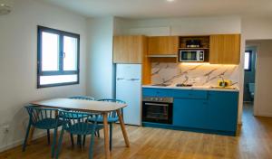 卡拉恩·布拉內斯Apartamentos Sol y Mar II的厨房配有蓝色橱柜和桌椅