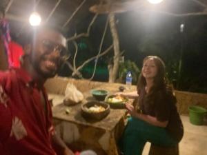 锡吉里亚Sigiriya Rastha Hostel的坐在餐桌旁吃饭的男人和女人