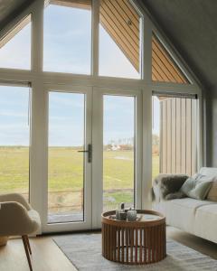 PietersbierumWad & Loft unieke paalwoning vlakbij de Waddenzee的带沙发和大窗户的客厅