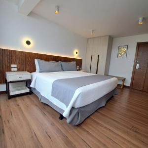 伊瓦拉Hotel Ajavi的卧室设有一张白色大床和木地板
