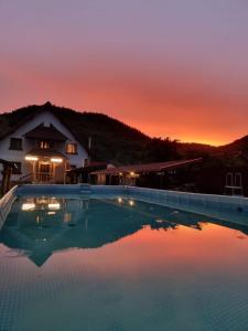 诺瓦齐- 斯特拉尼CONACUL DE SUB MUNTE的一座享有日落美景的游泳池