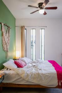 瓦哈卡市Azul Cielo Hostel的一间卧室配有一张带吊扇的床