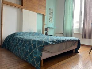 鲁贝Maison 5 chambres proche toutes commodités的卧室内的一张蓝色棉被