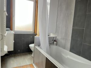 鲁贝Maison 5 chambres proche toutes commodités的带浴缸、卫生间和窗户的浴室