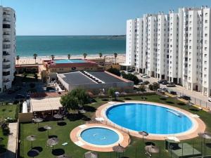 圣玛丽亚港Valdelagrana Mar Ha Apartment的享有度假胜地的空中景致,设有游泳池和海滩