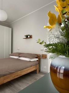 奥梅尼亚Casa Sophia的一间卧室配有床和黄色花瓶