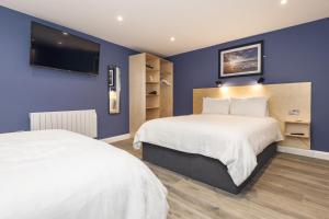 斯图尔特港Port 56的一间卧室设有两张床,墙上配有电视。