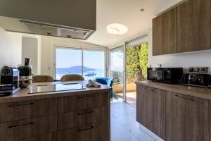 滨海自由城VILLA BELLE VUE VI4394 By Riviera Holiday Homes的一个带木制橱柜和大窗户的厨房