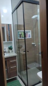 约恩维利Geminado Ibicaré com quarto privativo em casa compartilhada的浴室里设有玻璃门淋浴