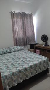 约恩维利Geminado Ibicaré com quarto privativo em casa compartilhada的一间卧室配有一张床、一张书桌和一个窗户。