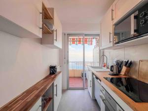 芒通Menton - Vue panoramique exceptionnelle ! 4Pers的一个带柜台的厨房和一个阳台