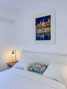 芒通Menton - Vue panoramique exceptionnelle ! 4Pers的卧室配有一张白色床,墙上挂着一幅画
