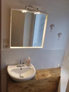 科尔尼蒙Joli appartement rénové (Hirondelle)的浴室设有白色水槽和镜子
