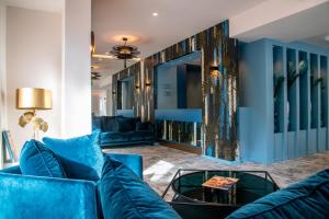 芒通Résidence Hôtelière Chambord的客厅配有蓝色的沙发和桌子