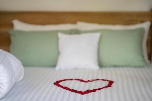莫希Mkoani Homestay的床上的红色心和枕头