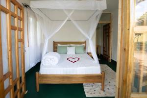 莫希Mkoani Homestay的一间卧室,配有一张心形床