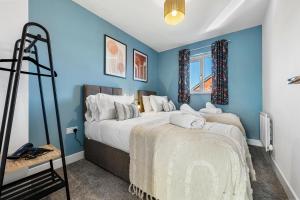 格洛斯特Stylish 4-Bedroom Townhouse with two large parking spaces and superfast Wi-Fi的一间拥有蓝色墙壁和一张大床的卧室